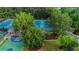 Aerial view of community tennis courts and basketball court amid lush landscaping at 12350 Edenwilde Dr, Roswell, GA 30075