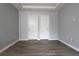 Bedroom with wood-look flooring, grey walls, white trim, and double closets at 225 Bentley Pl, Tucker, GA 30084