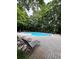 Relaxing community pool featuring clear blue water, plenty of lounge chairs, and mature trees offering a serene backdrop at 225 Bentley Pl, Tucker, GA 30084