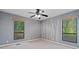 Bedroom with windows showcasing wooded backyard and custom vertical striping design feature on accent wall at 2683 Fleur De Lis Pl, Atlanta, GA 30360