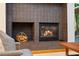 Close up of the fireplace with a basket of logs and view to the outdoor greenery at 2683 Fleur De Lis Pl, Atlanta, GA 30360