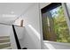 Upstairs hallway featuring a window overlooking trees and a staircase to the first floor at 2683 Fleur De Lis Pl, Atlanta, GA 30360