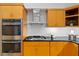 Kitchen with wood cabinets, stainless steel appliances, and a modern range hood at 2683 Fleur De Lis Pl, Atlanta, GA 30360