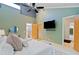 Bright main bedroom featuring a plush bed, ceiling fan, a door to an ensuite and one to a balcony at 2683 Fleur De Lis Pl, Atlanta, GA 30360