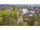 An aerial view shows a home on a wooded lot near a lake at 8920 Willowbrae Ln, Roswell, GA 30076