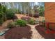 Wooded backyard featuring stone steps, gravel walkways, and manicured flowerbeds at 8920 Willowbrae Ln, Roswell, GA 30076