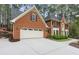 A charming two-story brick home features an attached two-car garage and a well-manicured lawn at 8920 Willowbrae Ln, Roswell, GA 30076