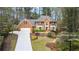 A stately two-story brick home features mature landscaping and a large driveway at 8920 Willowbrae Ln, Roswell, GA 30076