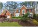 A beautiful brick home featuring a manicured lawn, mature trees and a two car garage at 8920 Willowbrae Ln, Roswell, GA 30076