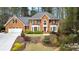 Charming two-story brick home featuring an attached two-car garage and lush landscaping with mature trees at 8920 Willowbrae Ln, Roswell, GA 30076