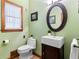 Charming half bathroom with a pedestal sink, decorative mirror, and modern fixtures at 8920 Willowbrae Ln, Roswell, GA 30076