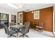 Cozy sunroom with wood paneling, multiple windows and a glass top dining table at 8920 Willowbrae Ln, Roswell, GA 30076