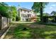 Large level backyard featuring a partially fenced yard with a wooded view and a wooden pergola at 915 Summer Wind Pl, Roswell, GA 30075