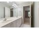 Bathroom with a double vanity and ample lighting featuring two sinks with gold fixtures at 915 Summer Wind Pl, Roswell, GA 30075
