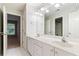 Bright bathroom with double sink vanity, white cabinets, and large mirror reflects ample natural light at 915 Summer Wind Pl, Roswell, GA 30075
