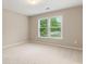 Neutral bedroom featuring a window with blinds, carpeted floor, and natural light streaming in at 915 Summer Wind Pl, Roswell, GA 30075