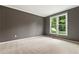 Cozy bedroom with soft carpet, neutral walls, white trim, and a bright window view at 915 Summer Wind Pl, Roswell, GA 30075