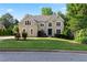 Charming tan home with a lush green lawn, decorative windows and mature landscaping at 915 Summer Wind Pl, Roswell, GA 30075