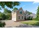 Beautiful tan two-story home with a two car garage, large driveway, lush lawn and mature trees at 915 Summer Wind Pl, Roswell, GA 30075