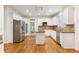 Modern kitchen with white cabinets, stainless steel appliances, granite countertops, and hardwood floors at 915 Summer Wind Pl, Roswell, GA 30075