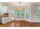 Sunlit breakfast nook features hardwood floors, a modern chandelier, and views of the backyard at 915 Summer Wind Pl, Roswell, GA 30075
