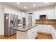 Modern kitchen featuring stainless appliances, granite countertops, white cabinets, and a spacious island at 915 Summer Wind Pl, Roswell, GA 30075