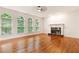 Elegant living room with hardwood floors, fireplace, and three arched windows at 915 Summer Wind Pl, Roswell, GA 30075