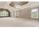 Expansive main bedroom with tray ceiling, carpet, and windows providing natural light at 915 Summer Wind Pl, Roswell, GA 30075