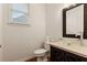 Elegant powder room with dark wood vanity, clear glass sink, and decorative mirror at 915 Summer Wind Pl, Roswell, GA 30075