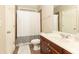 Neutral bathroom featuring a wood vanity, tiled floors, and white shower curtain offering simple elegance at 3110 Dickson Ne St, Brookhaven, GA 30319