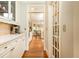 Hallway view with white cabinetry, hardwood floors, and view into dining area at 3110 Dickson Ne St, Brookhaven, GA 30319
