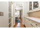 Hallway view with white cabinetry, hardwood floors, and view into dining area at 3110 Dickson Ne St, Brookhaven, GA 30319