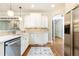 Bright kitchen features white cabinets, stainless appliances, and hardwood floors at 3110 Dickson Ne St, Brookhaven, GA 30319