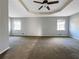 Expansive main bedroom with tray ceiling, ceiling fan, carpet, and natural light at 5211 Benjamin Trl, Ellenwood, GA 30294