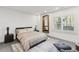 A modern bedroom featuring a large bed, a view through shuttered windows, and neutral colors at 8610 Sentinae Chase Dr, Roswell, GA 30076