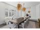 Modern dining room with a large table, contemporary lighting, and shuttered windows creating an elegant ambiance at 8610 Sentinae Chase Dr, Roswell, GA 30076