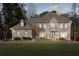 Stately two-story home with a lush green lawn and mature trees offering a serene and inviting curb appeal at 8610 Sentinae Chase Dr, Roswell, GA 30076