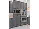 Close up of modern kitchen with stainless steel appliances and sleek gray cabinets at 8610 Sentinae Chase Dr, Roswell, GA 30076