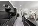 Contemporary kitchen with sleek black cabinets, stainless steel appliances, and a long island with seating at 8610 Sentinae Chase Dr, Roswell, GA 30076