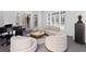 Bright living room boasts a piano, cozy seating area with plush chairs, and abundant natural light through large windows at 8610 Sentinae Chase Dr, Roswell, GA 30076