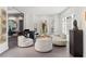 Modern living room with designer seating, piano, and decorative art creates a stylish and inviting space at 8610 Sentinae Chase Dr, Roswell, GA 30076