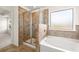 Well-lit bathroom featuring a glass-enclosed shower and a luxurious soaking tub at 13562 Whitman Ln, Covington, GA 30014