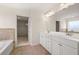 Bright bathroom featuring double vanity with white cabinets and a walk-in closet at 13562 Whitman Ln, Covington, GA 30014