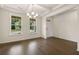 Dining room showcases hardwood floors, chandelier, and natural light from large windows at 13562 Whitman Ln, Covington, GA 30014