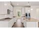 Modern kitchen with white cabinets, stainless steel appliances, and granite countertops at 13562 Whitman Ln, Covington, GA 30014
