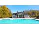 Community pool with a clubhouse surrounded by mature trees at 13562 Whitman Ln, Covington, GA 30014