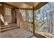 A view of a covered back porch of a brick home with wood railings and stairs at 24 Ball Creek Hl, Atlanta, GA 30350