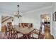Formal dining room with a large wooden table, chandelier, and access to the kitchen and staircase at 24 Ball Creek Hl, Atlanta, GA 30350