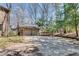Long driveway leading to a detached two-car garage and a traditional brick home with mature trees at 24 Ball Creek Hl, Atlanta, GA 30350