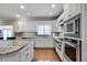 Bright, open kitchen boasts white cabinets, stainless steel appliances, and granite countertops at 24 Ball Creek Hl, Atlanta, GA 30350